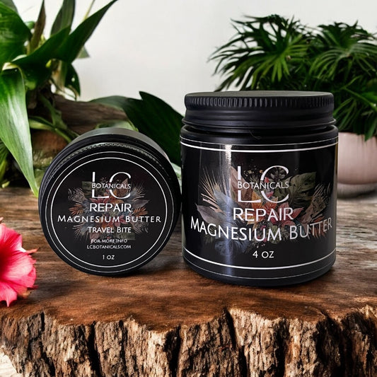Two jars of LC Botanicals Repair Magnesium Butter on a wooden surface with plants in the background.